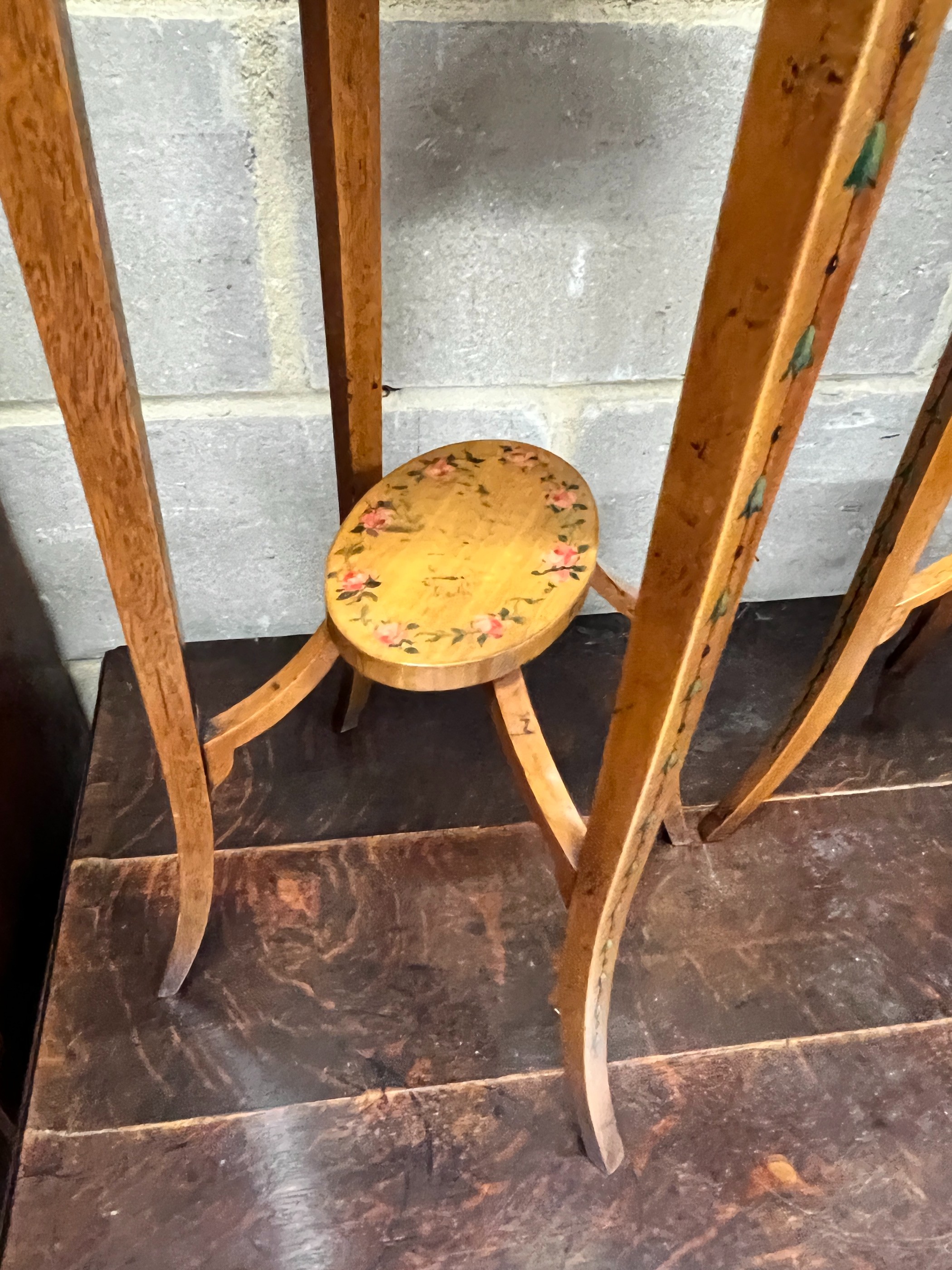 A pair of oval Sheraton style painted satinwood two tier plant stands, width 32cm, depth 26cm, height 71cm